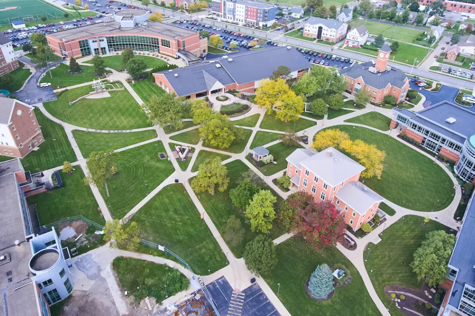 Aerial view of college campus with red brick buildings and green lawns.